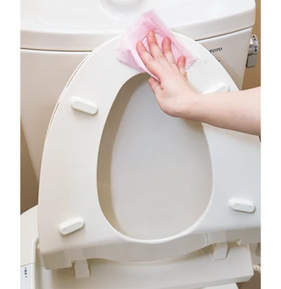 便座裏をトイレットペーパーで拭く