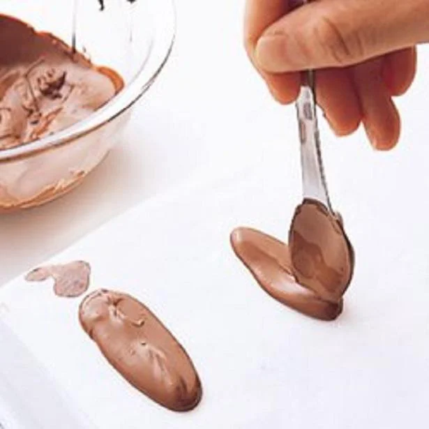 オーブン用ペーパーを敷き、溶かしたチョコレートをスプーンで円形か棒状に落とし、形を整える