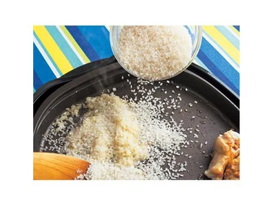 焼いた手羽元は脇に寄せ、玉ねぎとにんにくを炒めたところに生米を加えて炒める。米は芯を少し残し、パラッと仕上げたいので洗わずに加えて