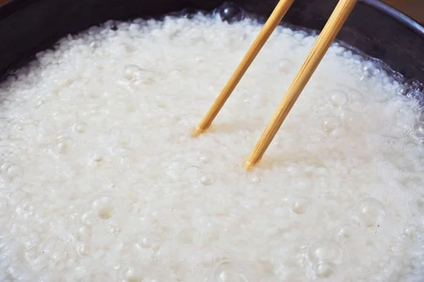 菜箸でフライパンの底についた米を取るようにかき混ぜる。再びふたをし、弱火にして約5分加熱