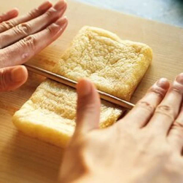 【画像を見る】油揚げの上で菜箸をコロコロと転がすと、きれいに開きやすくなる