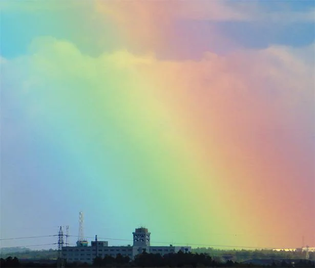 【画像を見る】虹のかかる街をズームで撮影すると、こんなにも美しい光景が…。