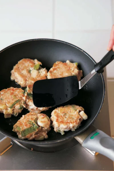 肉だねはへらで押して円盤形にして焼きつける【てりてりつくね】