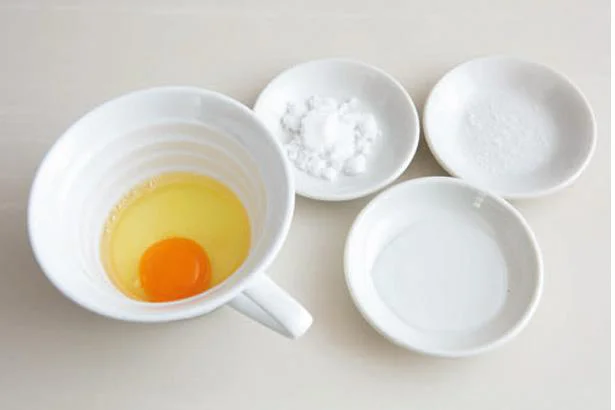 容器に卵を割り入れ、水と調味料を加えて溶きほぐす。