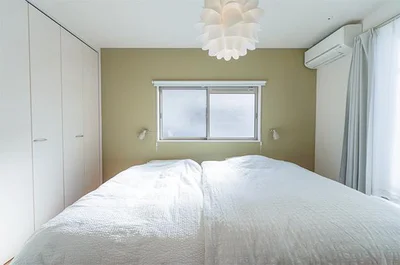 アクセントウォールが映える白に囲まれた清潔な寝室