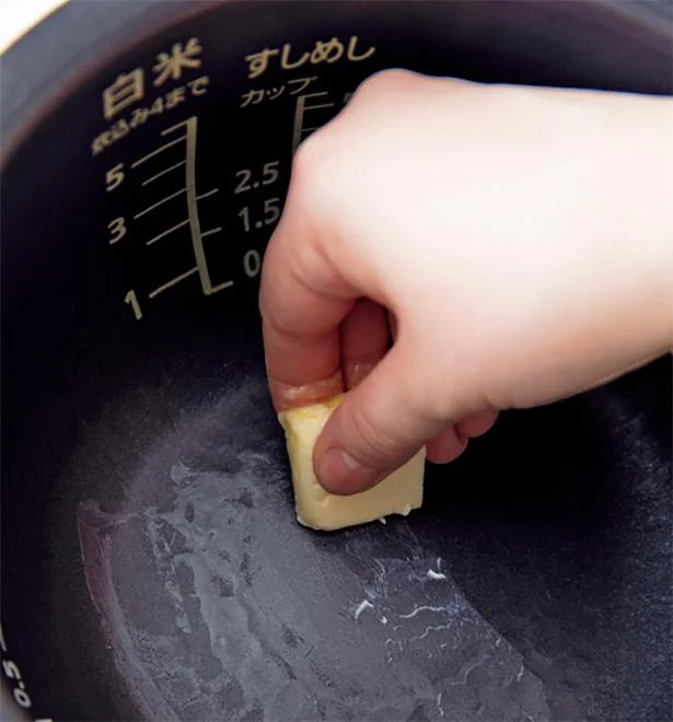 炊飯器の内釡にバターまたは油（いずれも分量外）を薄く塗る