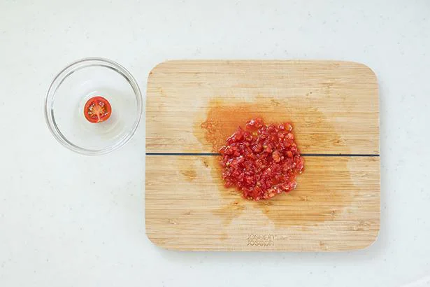 作り方１：ミニトマトは縦半分に切る。1つを飾り用に、取り残りは粗みじん切りにする。
