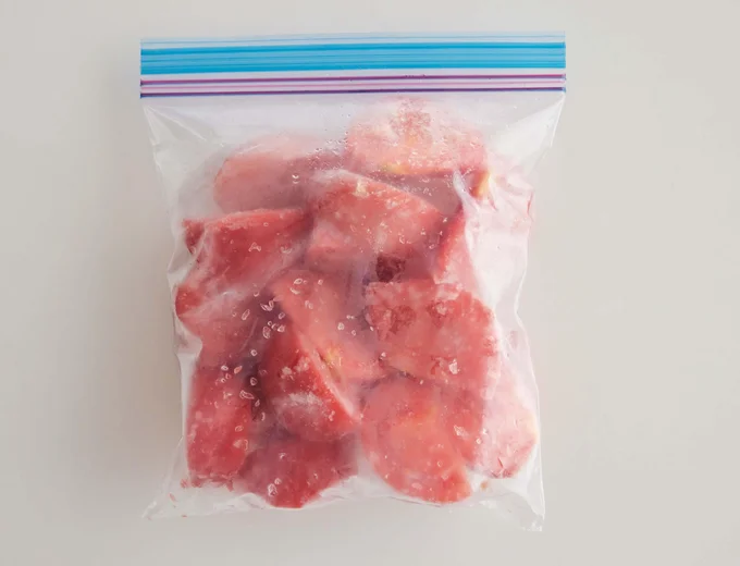 6〜8等分に切ったトマトを、冷凍用保存袋にできるだけバラバラになるよう広げて入れ、バットにのせて平らに冷凍。