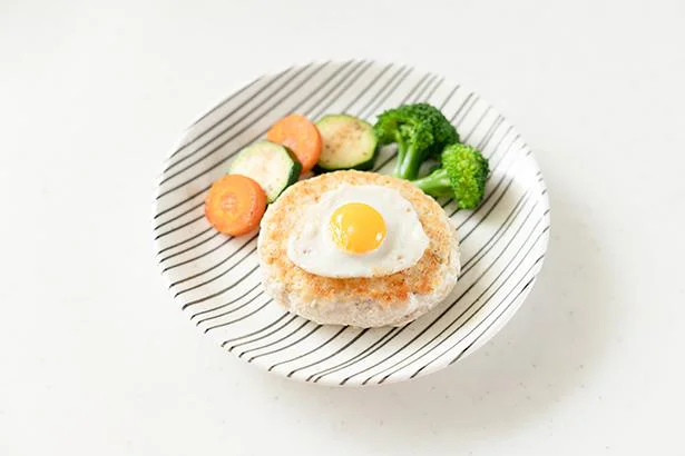 皿にハンバーグを置き、うずらの目玉焼きをのせる。にんじん、ズッキーニ、ブロッコリーを添えて出来上がり!