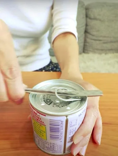 スプーンの先を缶詰のプルタブに通す