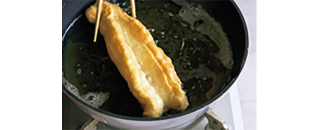 箸で生地を回転させ、ふくらませながらきつね色になるまで揚げる