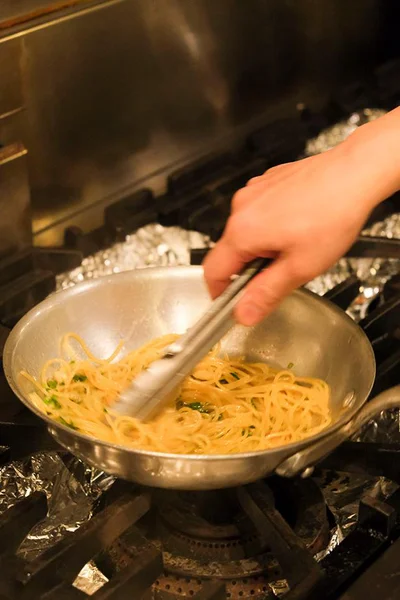 パスタを加えたら麺に水分を吸わせないようにすばやく混ぜる