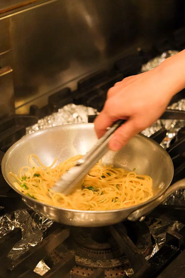 パスタを加えたら麺に水分を吸わせないようにすばやく混ぜる