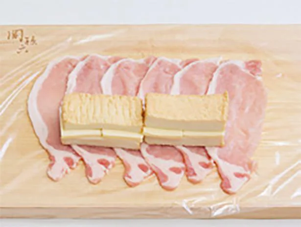 ラップを広げ、厚揚げにチーズを挟んで豚肉の上にのせ、左右を内側に折り込みながら手前から巻く