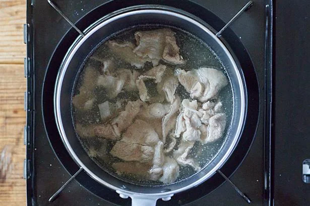 鍋に水を入れて強めの中火で沸騰させ、豚こま切れ肉を加えて火が通るまで加熱する