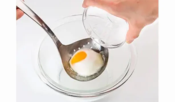 【水けをきる】温泉卵をそっと穴じゃくしにあけて水けをきる。穴じゃくしがない場合は、大きめのスプーンなどで温泉卵を軽く押さえながら水けをきる。器に盛り、好みでめんつゆをかける。