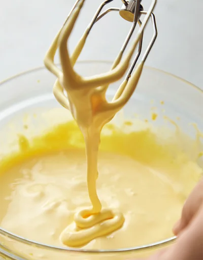 卵黄にグラニュー糖50gを加え、ハンドミキサーで白くもったりするまで泡立てる