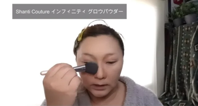 ブラシに少しラメの入ったフェイスパウダーを取り、さきほどのシャドウをぼかすように顔全体に広げます