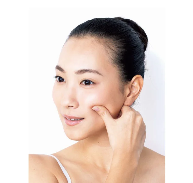1．反対の手の親指をほお骨の下に当てる