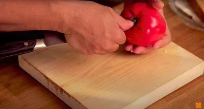 トマトのヘタの部分に包丁の先端を刺す