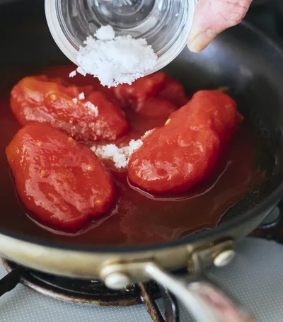 半端に残ったトマト缶に塩を加えてフライパンへ。