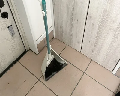 玄関を掃除するほうき