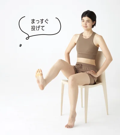 つかみ上げたキャップを前方へまっすぐ放り投げる