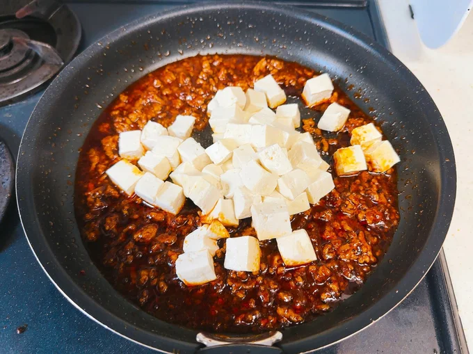 豆腐を加えたら、くずれないように静かにかき混ぜて