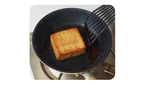 熱したフライパンにバターを溶かし、厚揚げの両面を焼く
