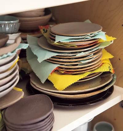 たくさんある皿は破損防止のための布をかませて重ねる収納
