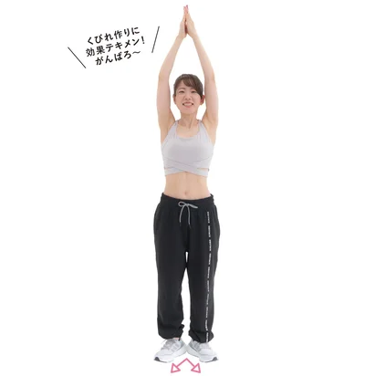 両腕を頭の上に伸ばし手のひらを合わせる