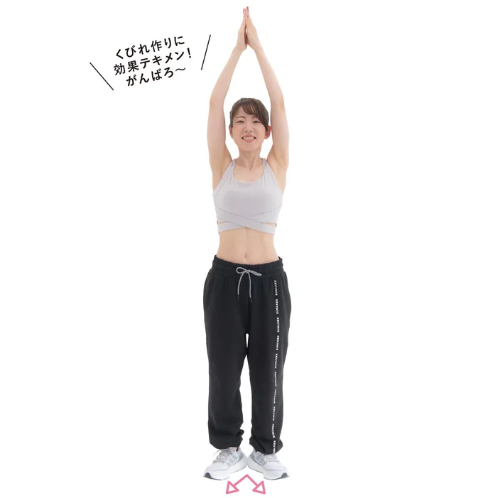 両腕を頭の上に伸ばし手のひらを合わせる