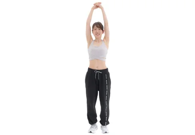両腕を頭の上に伸ばし左右の手の指を組む