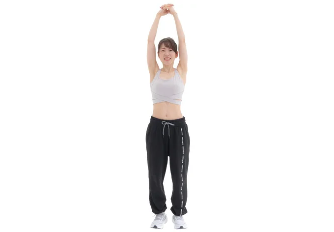 両腕を頭の上に伸ばし左右の手の指を組む