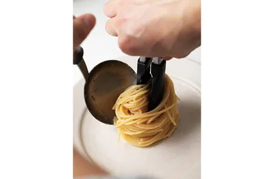 お玉をずらすように動かしてスパゲッティを皿に移す