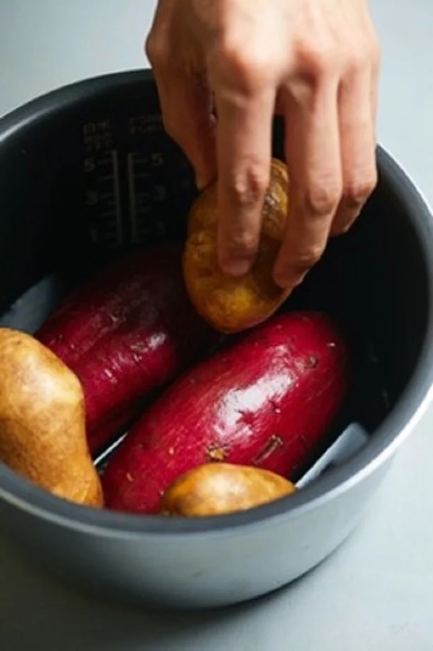 炊飯器の内釜にさつまいもを並べ、さつまいもの1/4の高さまで水を注ぐ。