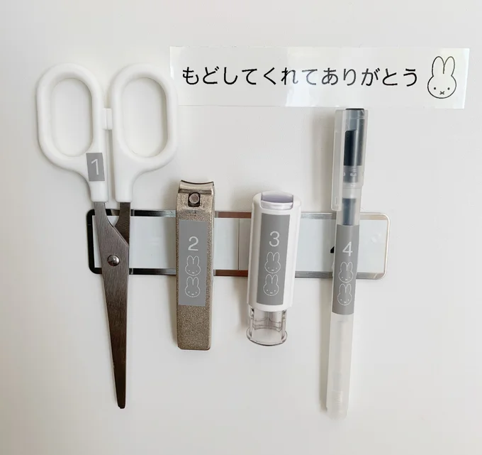 はさみなどそれぞれに 100 円の強力マグネットを貼りつけ、収納の扉裏に取りつけたマグネット補助プレートにペタッ