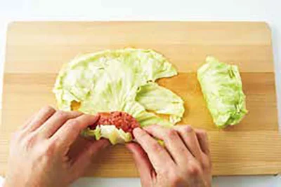 2を1枚広げ、手前に1の半量を軽くまとめておく。葉を手前からひと巻きし、左右を折りたたんでくるくると巻き、巻き終わりを楊枝で留める