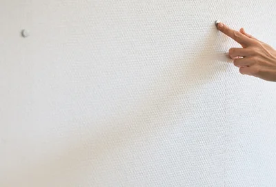 ネオジム磁石を壁に当てていくと、ピタッとつく場所があるはず。そこがネジ留めの場所＝柱の位置。
