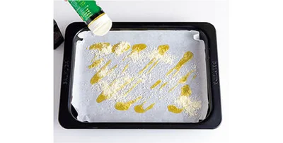 3. 天板にクッキングシートを広げ、粉チーズ適量、オリーブ油をざっと広げる。