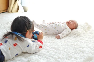 赤ちゃんにカメラを構えるお姉ちゃん。真剣な表情の先には？▶次はお姉ちゃんの本気が溢れるポスト（⇒次へ）