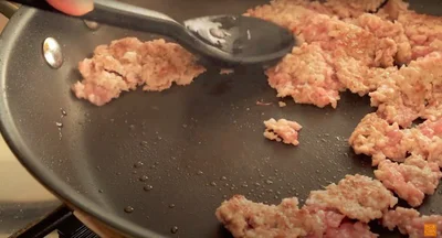 ひき肉のかたまりを押しながらほぐす