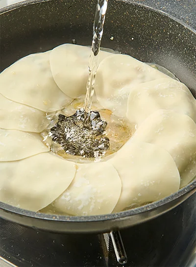 水を中心から注ぎ、ふたをして5分蒸し焼きにする