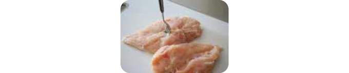 鶏肉の皮をはぎ、拳で叩いてフォークで大量に穴をあけ、そぎ切りにする。