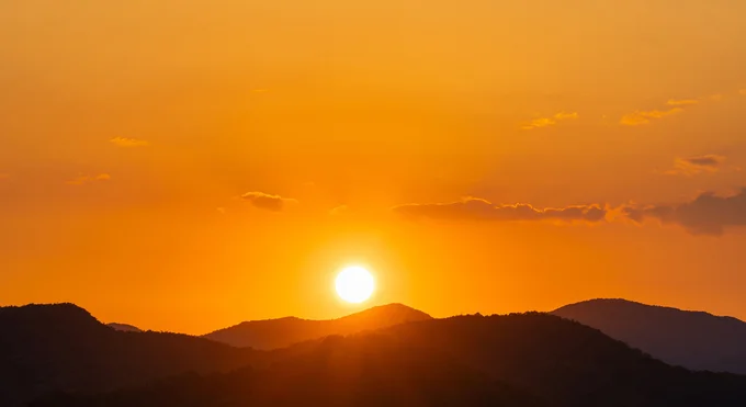 地平線や水平線に沈む太陽が、昼間の太陽よりも大きく見えた