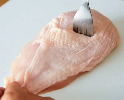 レンチンサラダチキンの作り方1　とりむね肉 大1枚（約300g）は、皮の面をフォークで10カ所ほど刺す。（作り方2に続く▶︎次へ）