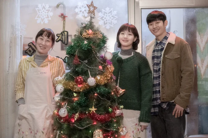 クリスマスツリーの横で幸せそうに微笑む3人