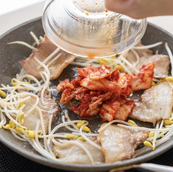 フライパンの中央を開け、キムチを入れて焼き付ける