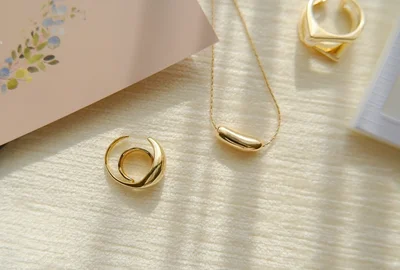 ゴールドのツヤ感が高級感のあるネックレスとイヤカフ