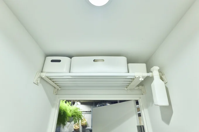 扉の上にあるデッドスペースを利用して、トイレに使う掃除道具とストック品を収納